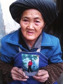 2012年12月9日,在云南省巧家县崇溪乡南团村钱粮社钱仁凤的家里,72岁的钱母手持女儿照片盼女早归。